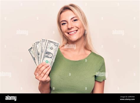 Jeune belle femme blonde tenant un bouquet de billets de dollars plus arrière plan blanc