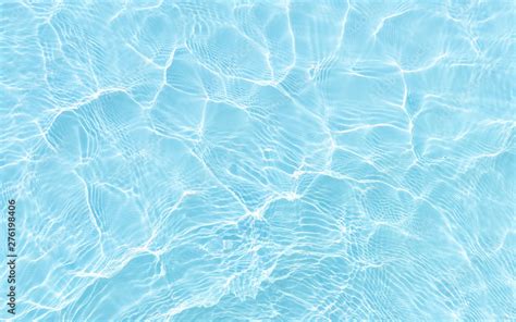 Bright Ripple Surface Of Light Blue Swimming Pool With Sun Reflect View