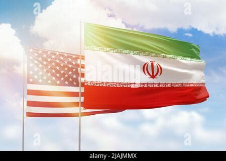 USA And Iran Flags Waving Together In The Wind On Blue Cloudy Sky Two