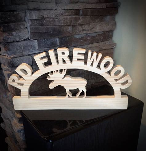 A Wooden Sign That Says Red Firewood With A Moose In The Center On Top