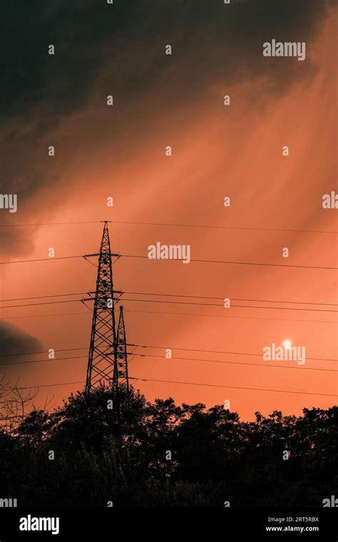 Dark Ominous Stormy Clouds At Orange Summer Sky Silhouettes Of