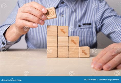 Man Building Career Ladder From Wooden Blocks With Arrows Business