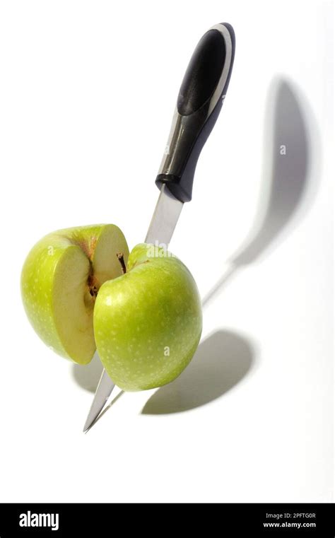 Floating Green Apple Cut In Half By Knife On White Background Stock