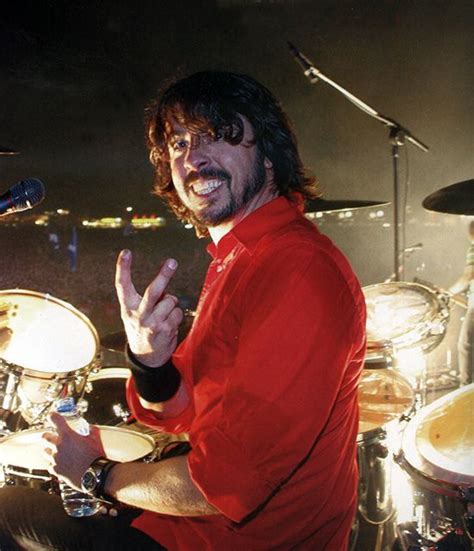 a man in red shirt playing drums on stage