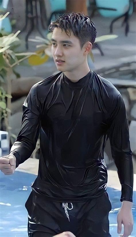 A Man In Black Wetsuit Standing Next To A Swimming Pool With His Hand Out