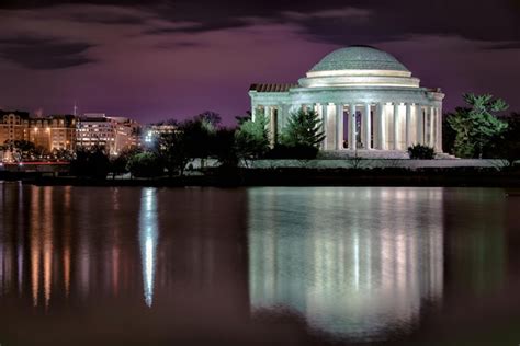 Premium Photo | Reflection of building in water at night