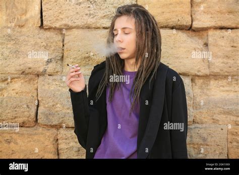 Young boy smoking weed on stone wall background Stock Photo - Alamy