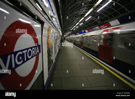 Tube Logo And Train Arriving At Victoria Underground Station London