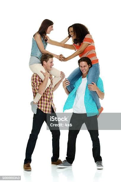 Two Women Fighting On The Shoulders Of Men Stock Photo Download Image