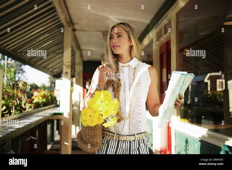 Young woman with map in verandah Stock Photo - Alamy