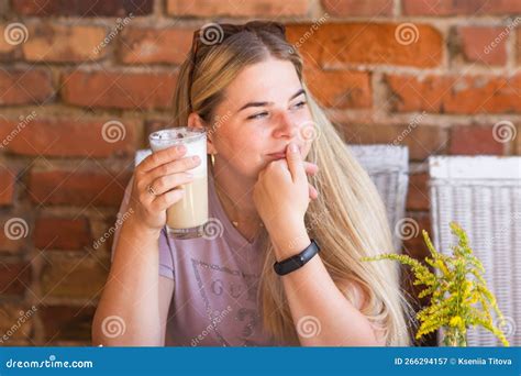 Smiling Blonde Woman With Wristwatch Drinking Coffee Latte In Cafe