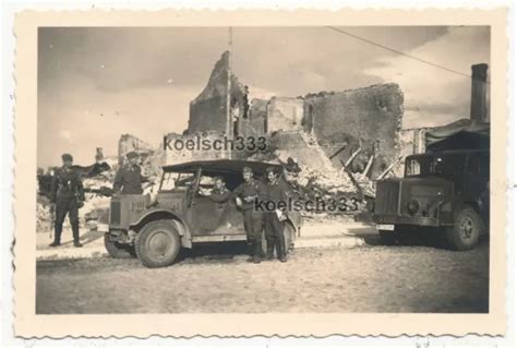 FOTO KÜBELWAGEN PKW und LKW der Luftwaffe vor Ruinen in Oberschlesien