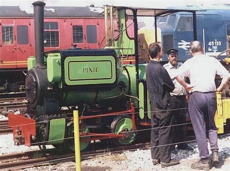 several men are standing next to a train on the tracks and one man is ...