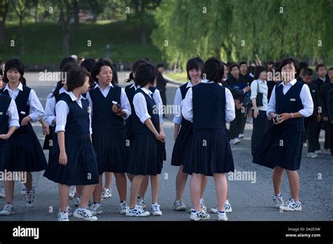 A Group Of Japanese High School Girls In Uniform On A Field Trip To The Imperial Palace In The