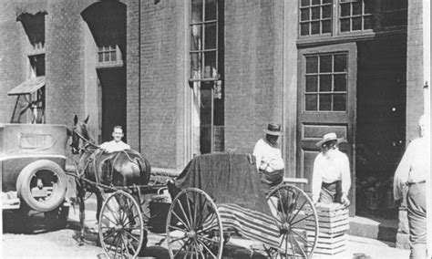 an old black and white photo of people standing in front of a horse ...