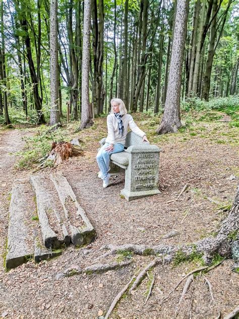 Girl Sitting On An Old Stone Bench In The Forest In Spa Resort