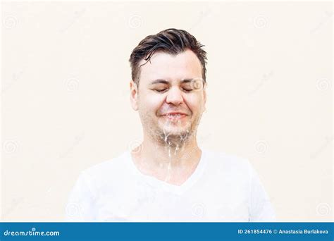 Wet Young Caucasian Man In White T Shirt With Closed Eyes And Water Is