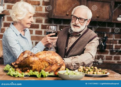 Senior Couple Drinking Wine On Thanksgiving Dinner With Turkey Stock