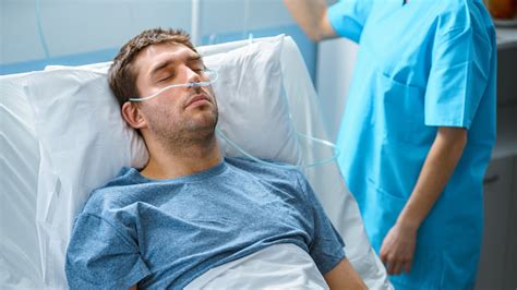 In The Hospital Sick Male Patient Sleeps On The Bed Nurse Enters