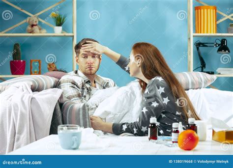 Sick Man With Fever Lying In Bed Having Temperature Girl Take Care For