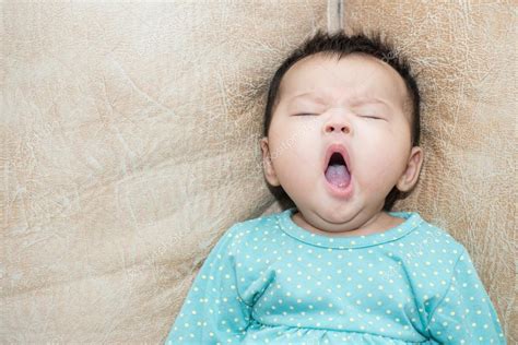 Portrait Of A Yawning Baby Girl On A Leather Background Stock Photo By