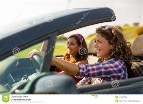 Dos Muchachas Hermosas Jovenes Que Conducen En Un Convertible Imagen De