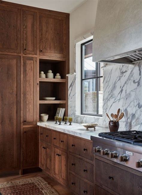 Brown Rustic Cabinetry With White And Gray Honed Marble Slab Backsplash