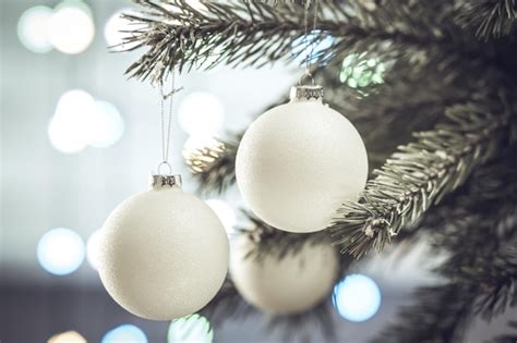 Composición navideña hermosas bolas blancas en una rama del árbol de