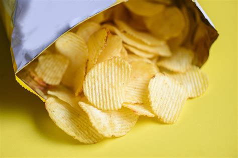 Potato hips on yellow background, Potato chips is snack in bag package wrapped in plastic ready ...