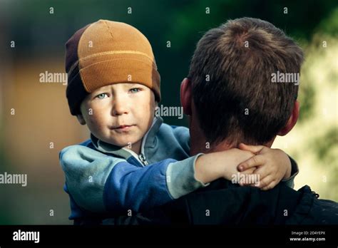 Triste petit garçon dans les bras de son père Photo Stock Alamy