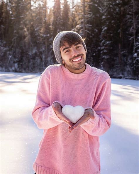 A Man Holding A Heart In His Hands While Standing On The Snow Covered