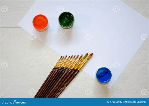 Pinceles Sobre Una Hoja Blanca De Papel Junto A Pinturas De Diferentes