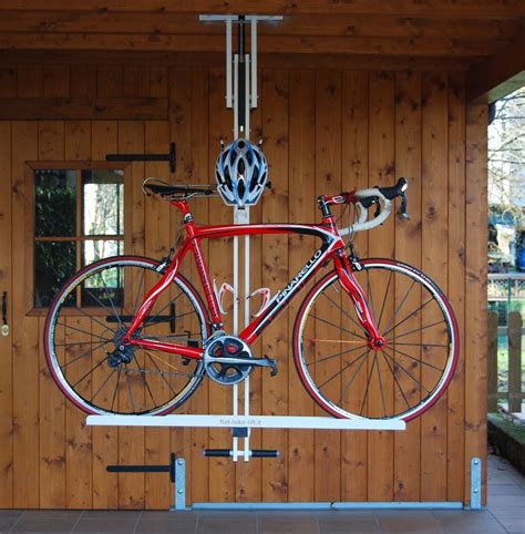 a red bike hanging from the side of a wooden building