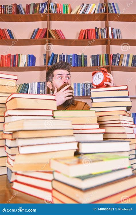 Man Scientist Peeking Out Of Piles Of Books With Alarm Clock Teacher