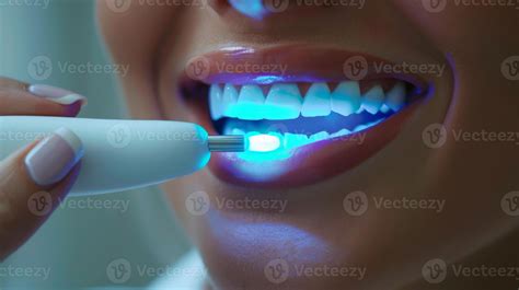 A person undergoing a teeth whitening procedure using a handheld device