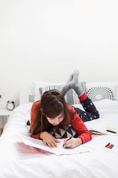 Une Fille Allongée Sur Le Lit Dessiner Avec Des Crayons Colorés