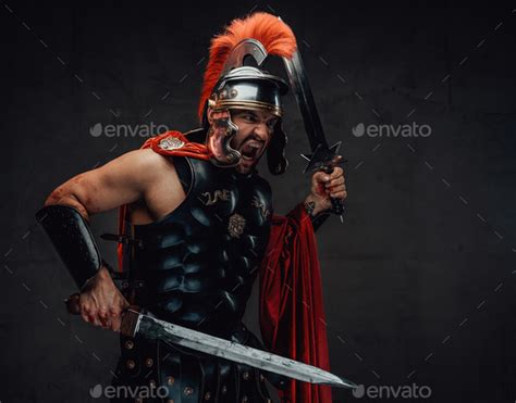 Screaming And Savage Roman Warrior With Swords And Armour Stock Photo