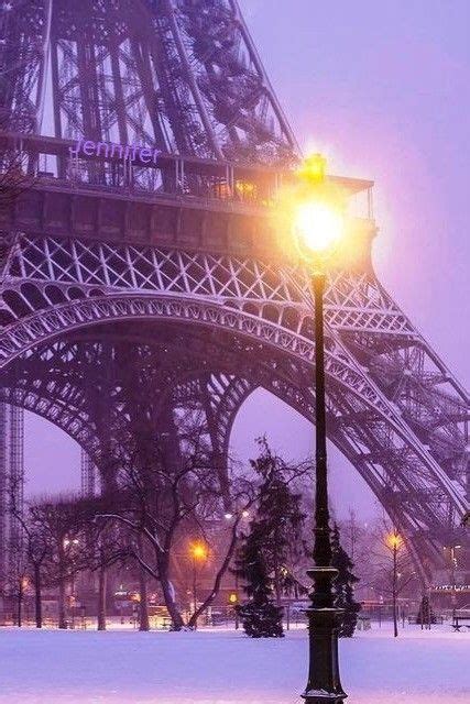 The Eiffel Tower Is Lit Up At Night In The Snow Covered City Park