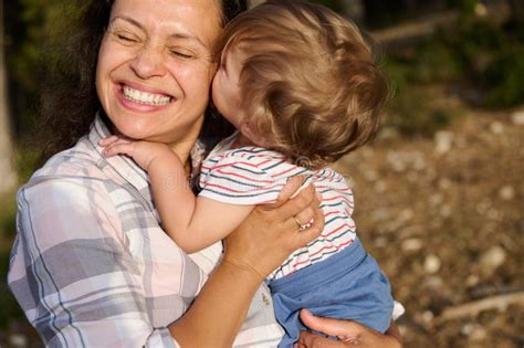 Happy Grandmother Holding Grandson Outdoors Sharing A Loving Moment In