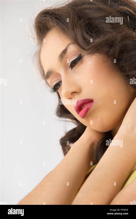 Profile Head Shot Of Beautiful Young Woman Looking Down With Hands On