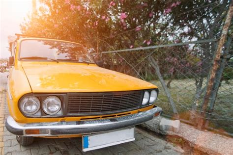 Coche Amarillo Estacionado En Una Calle Soleada De La Ciudad Foto Premium