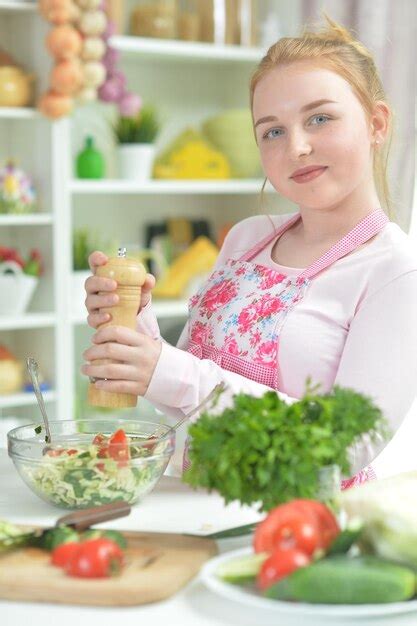 Premium Photo Cute Teen Girl Preparing Fresh Salad On Kitchen Table