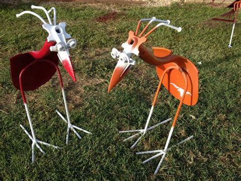 Two Orange And White Birds Are Standing In The Grass With Forks