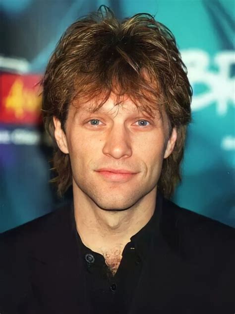 A Close Up Of A Person Wearing A Black Shirt And Suit With His Hair