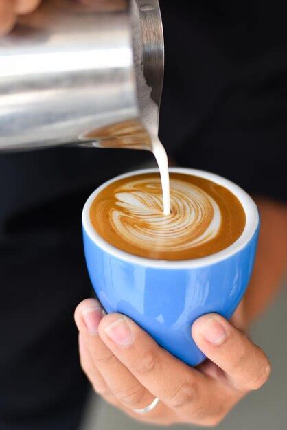 Premium Photo Close Up Of Hand Pouring Milk In Coffee