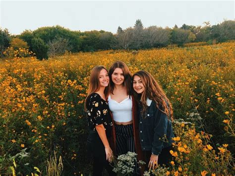 Three Young Women Standing In A Field Of Flowers