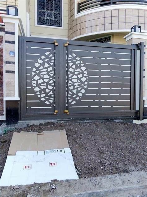 A Large Gate With An Intricate Design On It In Front Of A House That Is