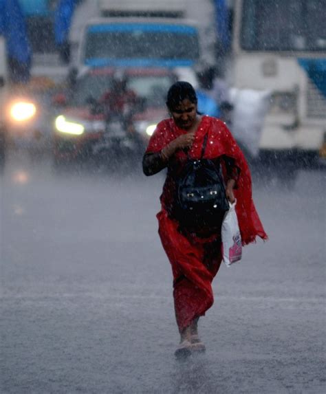 Kolkata : A women walks amid pre-monsoon showers