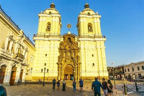 people are walking around in front of a large building with two towers ...