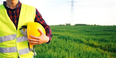 Premium Photo | Construction worker holding yellow hard hat and wearing ...